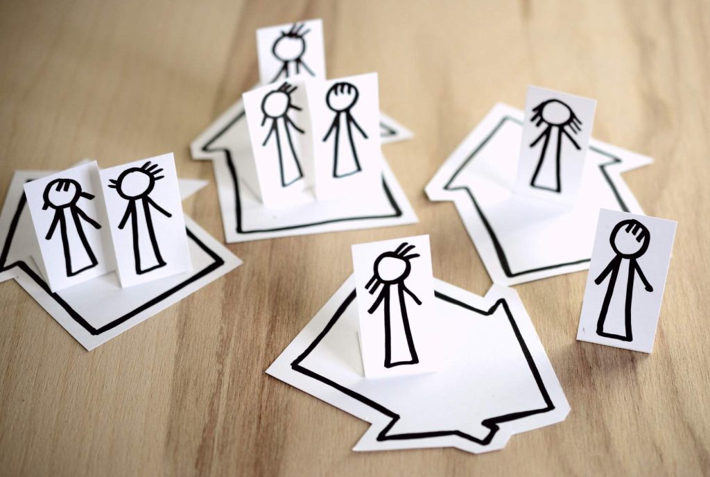 Family and Community Engagement:
"Paper cutouts of stick figure people arranged in groups, symbolizing diverse family and community connections."